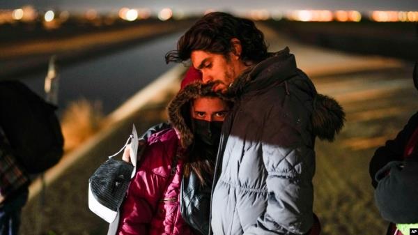 FILE - A couple from Cuba wait to be processed to seek asylum after crossing the border into the United States, near Yuma, Arizona, Jan. 6, 2023.